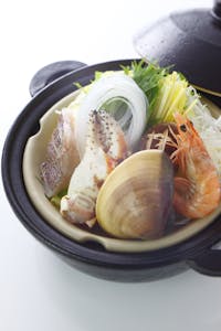 An exquisite seafood hotpot featuring fresh shrimp, shellfish, and vegetables, beautifully presented.