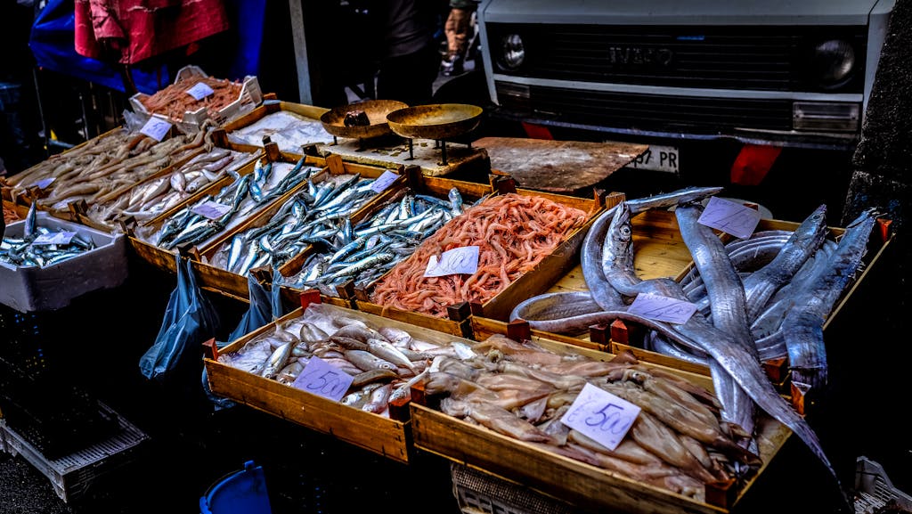 Colorful seafood display at an outdoor market featuring fresh fish, shrimp, and prawns.